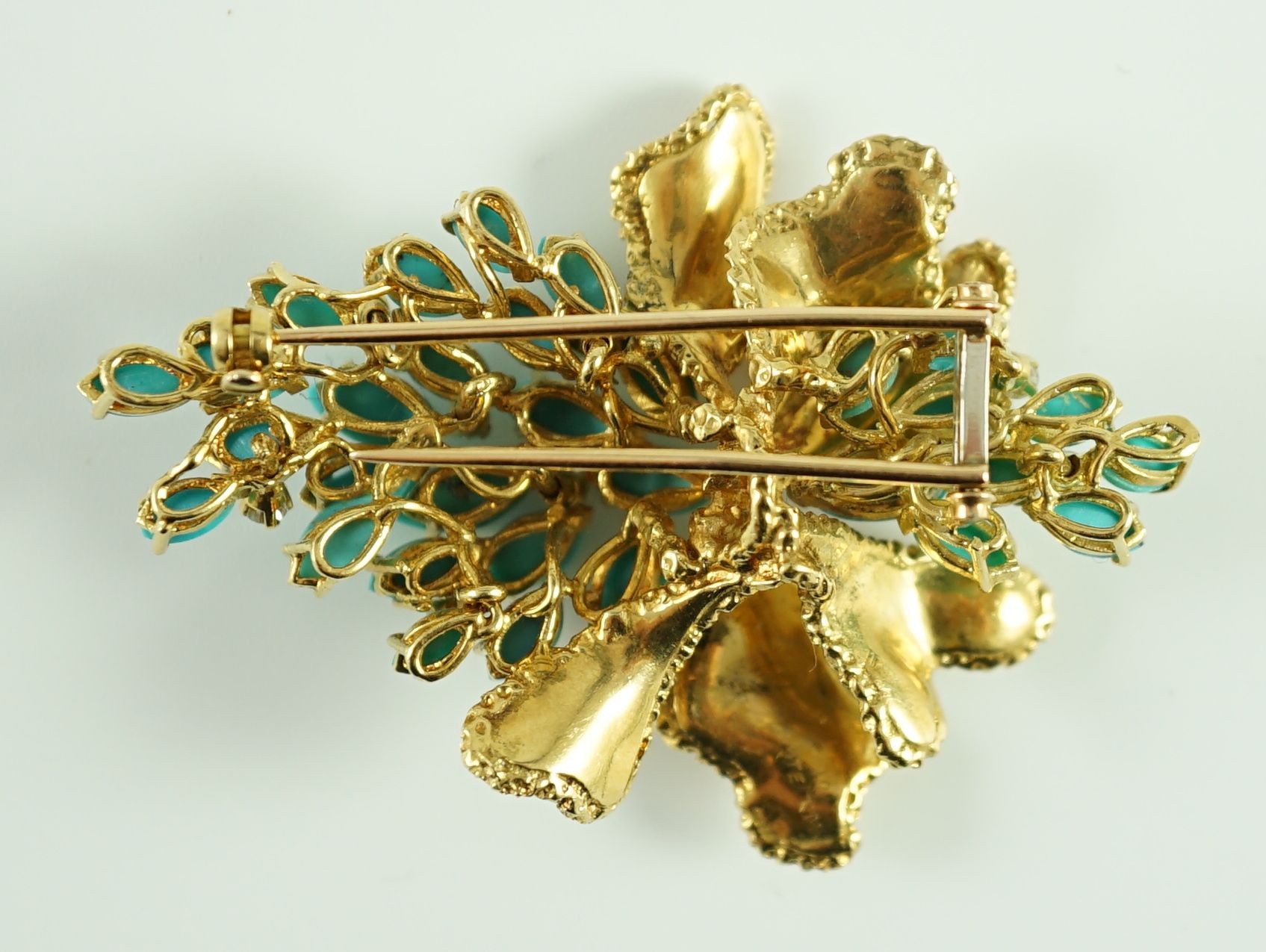 A 1970's textured 18ct gold, turquoise and diamond set cluster clip brooch